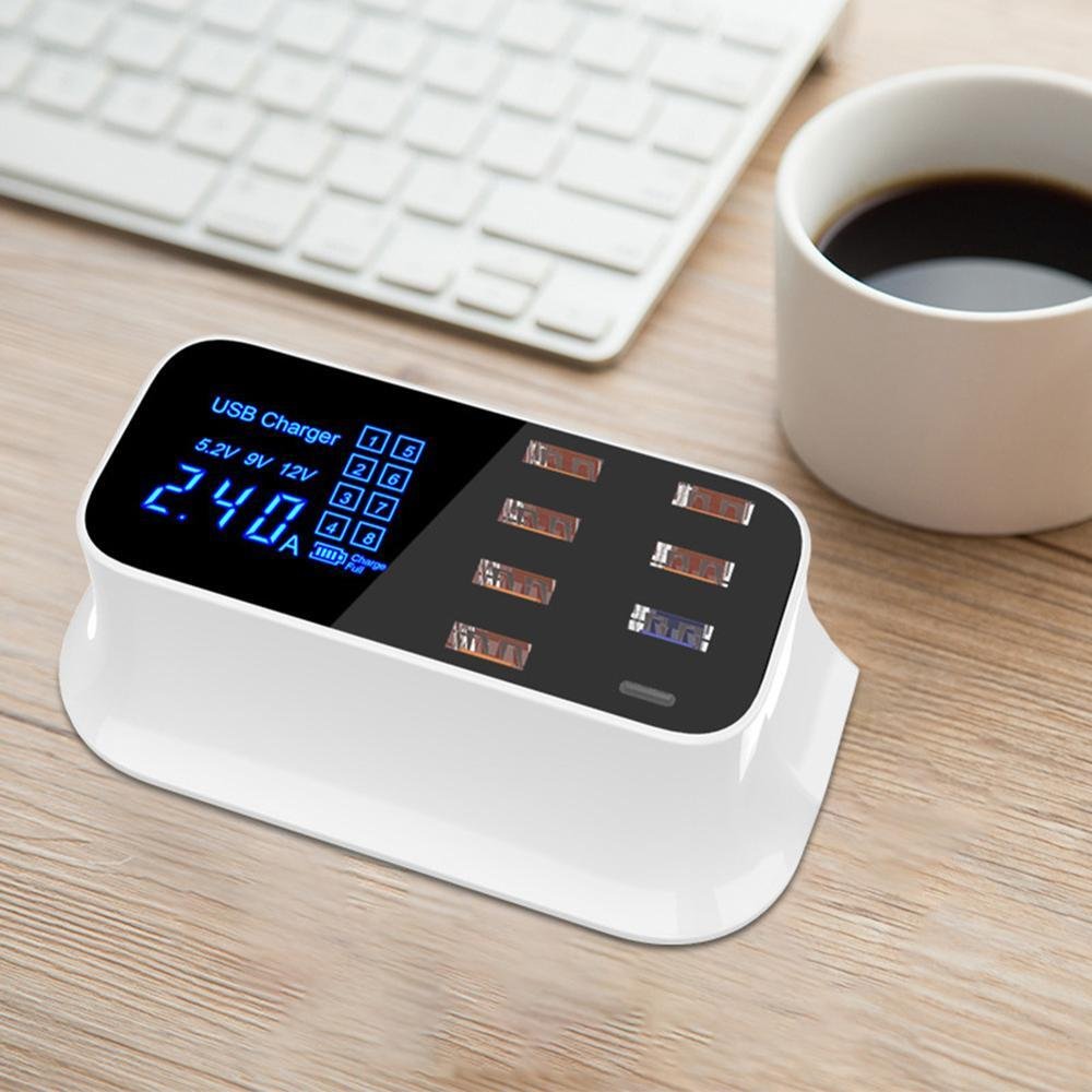 USB charger with digital display on a desk next to a keyboard and coffee cup