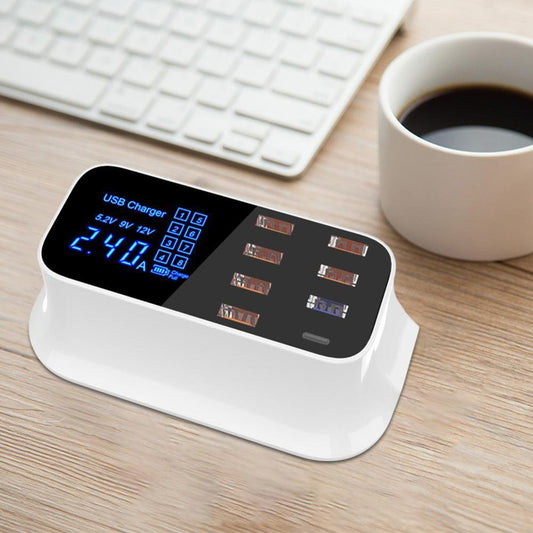 USB charger with digital display on a desk next to a keyboard and coffee cup