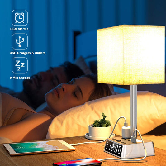 Table lamp with clock and USB ports on a bedside table, with a person sleeping in the background.