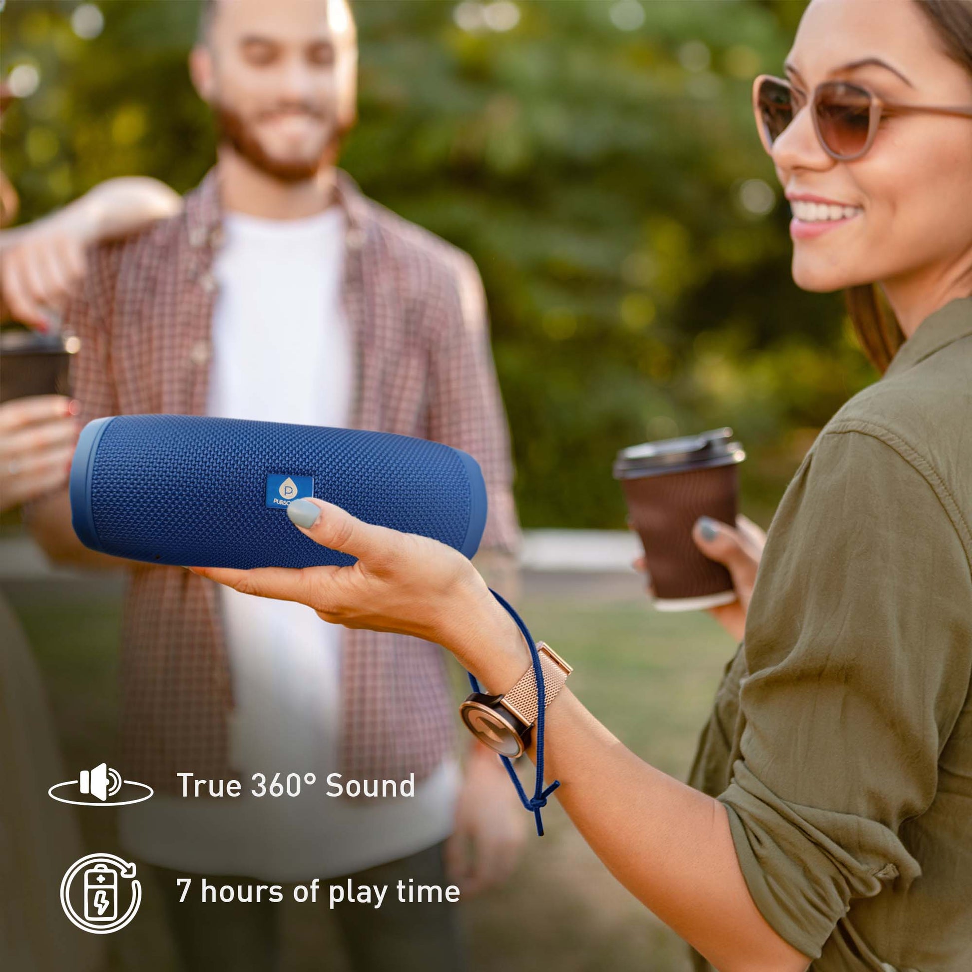 Woman holding a blue Bluetooth speaker with text about sound quality and play time, outdoors.